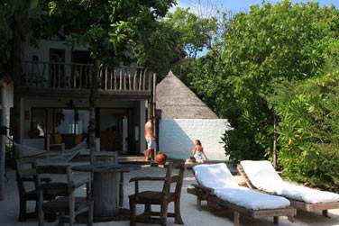 L'espace extrieur amnag de la Suite Crusoe 2 chambres avec transats les pieds dans le sable