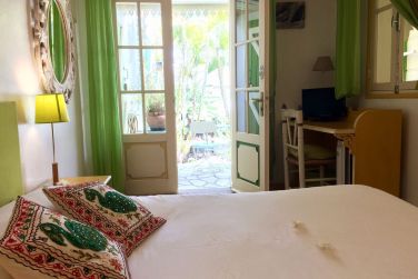 Intrieur d'une chambre de la Case Nyala avec sa porte donnant sur la terrasse