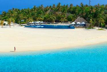 Une plage de sable blanc et un lagon turquoise accessibles par bateau.