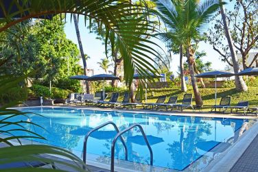 La piscine est entoure d'une vgtation luxuriante