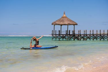 Sur la plage, sur une planche de paddle, pratiquez le yoga partout !