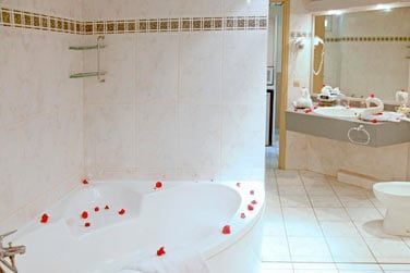 Salle de bain avec baignoire en chambre Deluxe