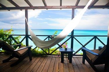 Vue imprenable sur le lagon turquoise depuis le balcon du Sunset Cottage