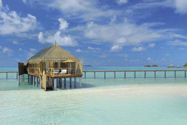 Les villas sur pilotis sont poses sur les eaux turquoise du lagon entourant l'htel