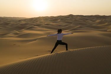 Rvillez vous en pratiquant votre yoga matinal sur les dunes du d'Abu Dhabi