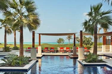 De la piscine, le cadre est splendide : le parcours de golf verdoyant et la mer turquoise en toile de fond