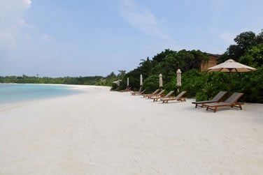 L'htel est bord par une longue plage de sable fin caresse par une eau turquoise...