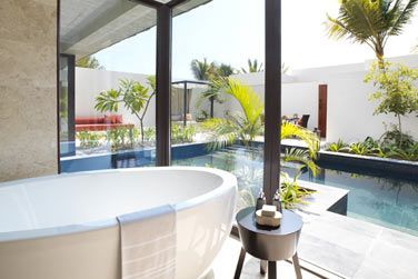 La salle de bain de la villa vue jardin avec piscine