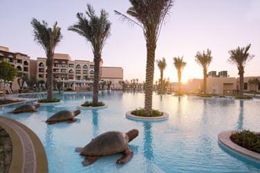 Magnifique vue sur la piscine du Resort, des statues de tortues bordant celle-ci et arbore de palmiers majestueux