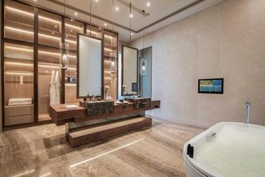 Salle de bain luxueuse de la suite royale offrant une grande baignoire et des douches au design moderne et pur