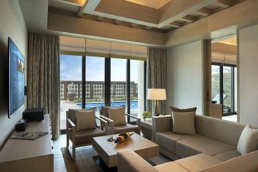 Salon de la villa 1 chambre au design pur, moderne et aux tons beiges et bruns