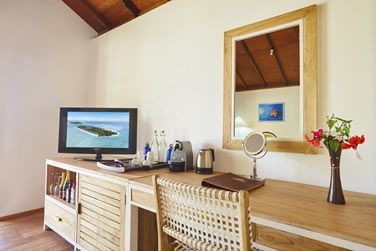 Salon lumineux et rustique du Sunrise beach bungalow, spacieux aux tons tropicaux