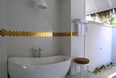 La grande villa plage possde une baignoire pure aux dorures et aux tons blancs