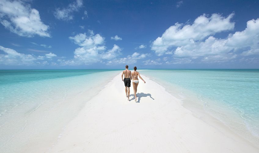couple marchant sur la plage aux Bahamas