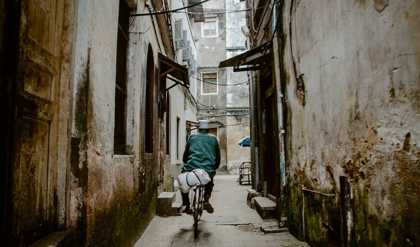 homme faisant du vlo dans une ruelle de Stone Town