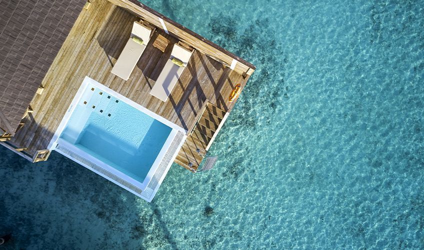 vue arienne d'une piscine sur pilotis au Sun Siyam Olhuveli aux Maldives
